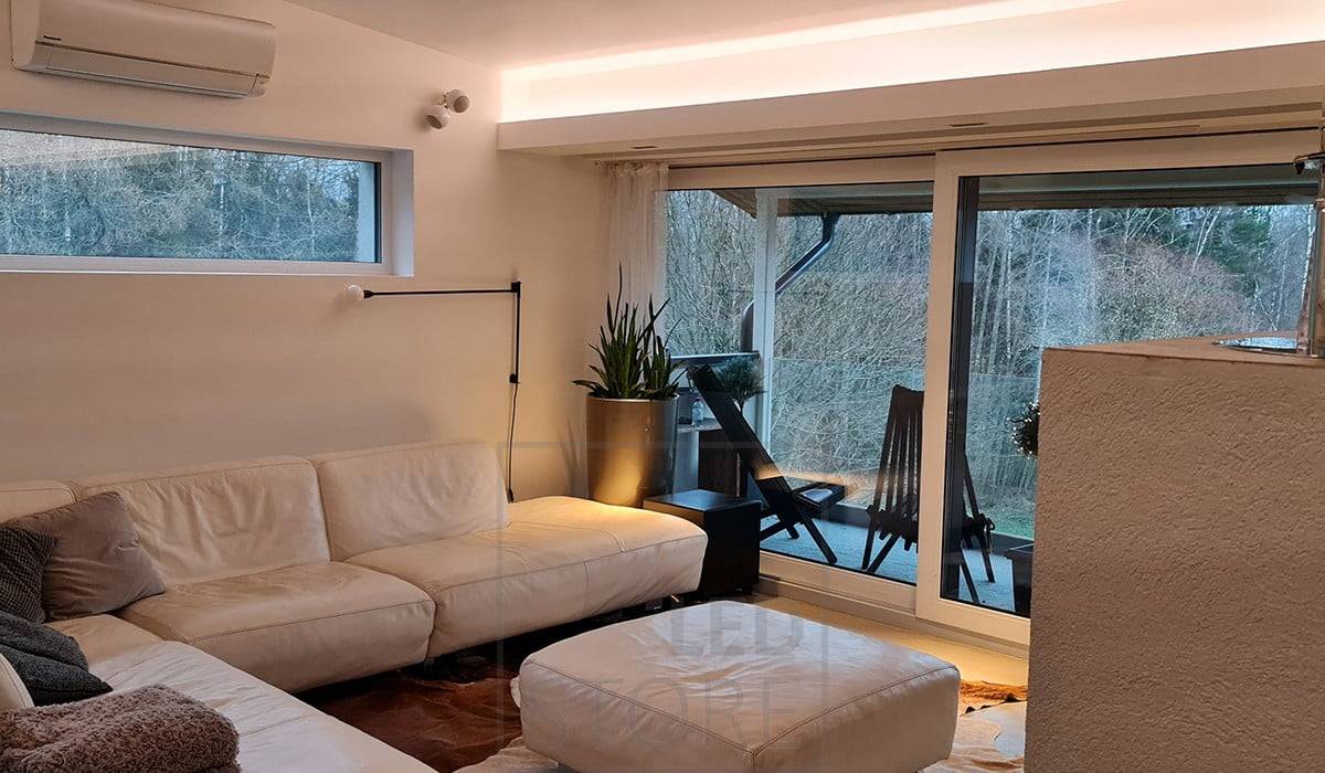 Un aplique desplegable para el salón con una tira de LED dirigida al techo que crea una hermosa iluminación ambiental.